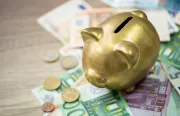 Piggy bank sitting on Euro notes
