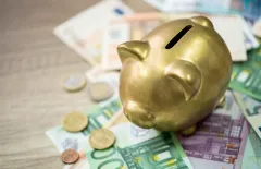 Piggy bank sitting on Euro notes
